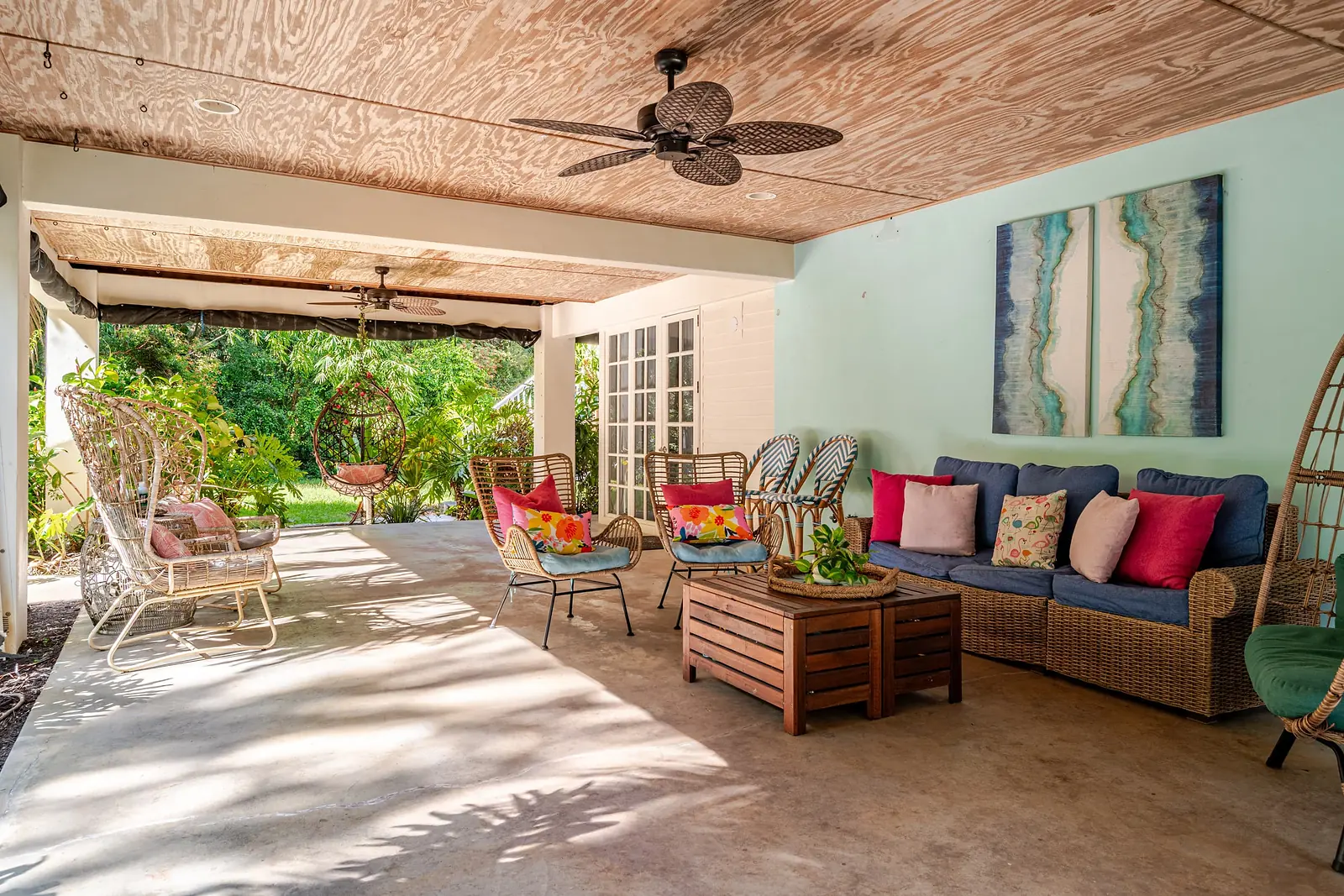 Covered lanai lounge with wicker chairs and bright cushions