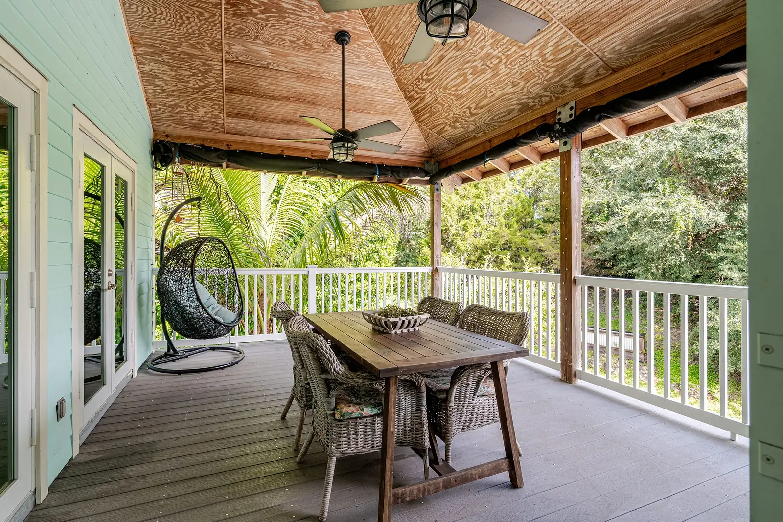 Upper balcony with a dining table and a hanging egg chair
