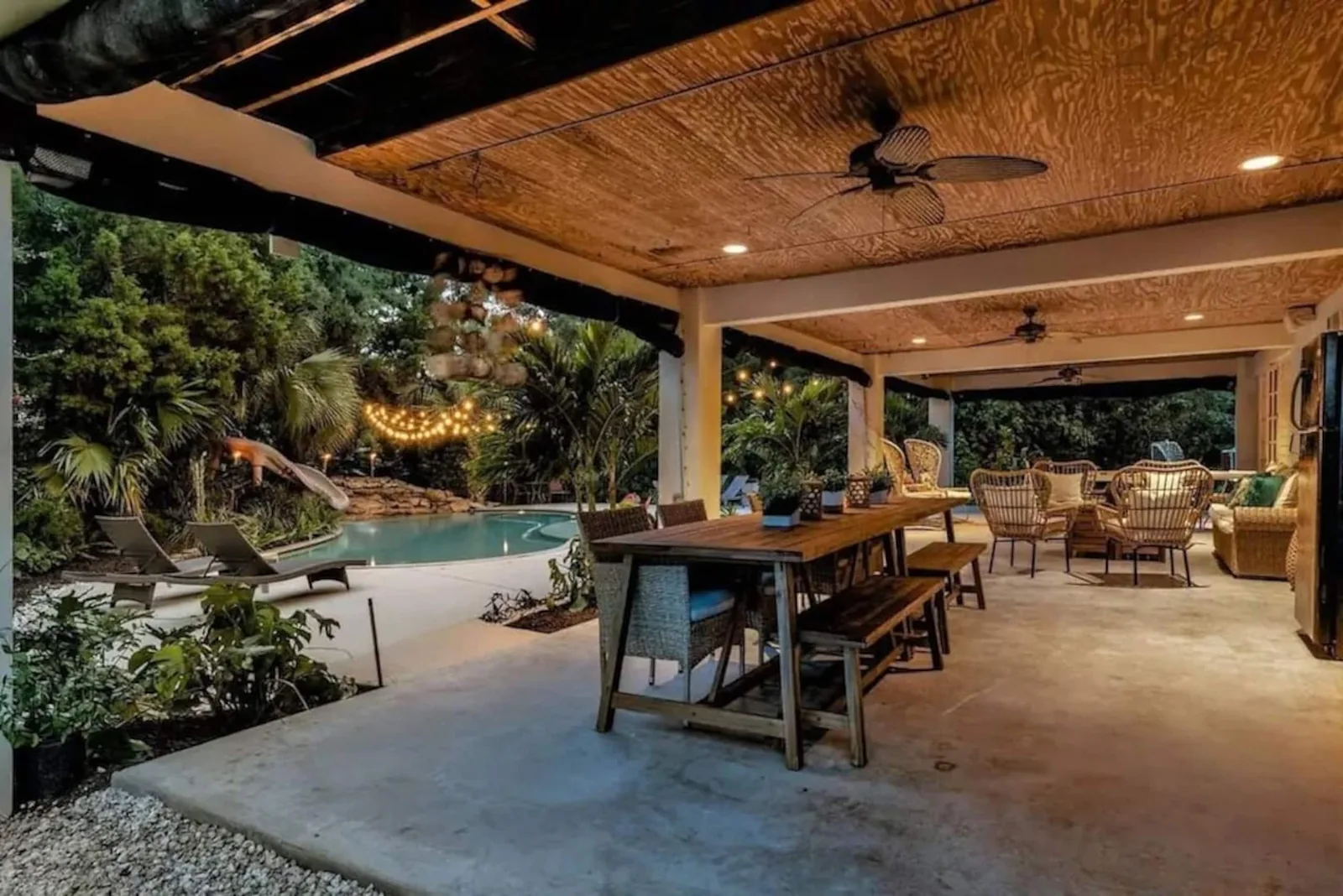 Covered lanai dining table at dusk, the pool beyond