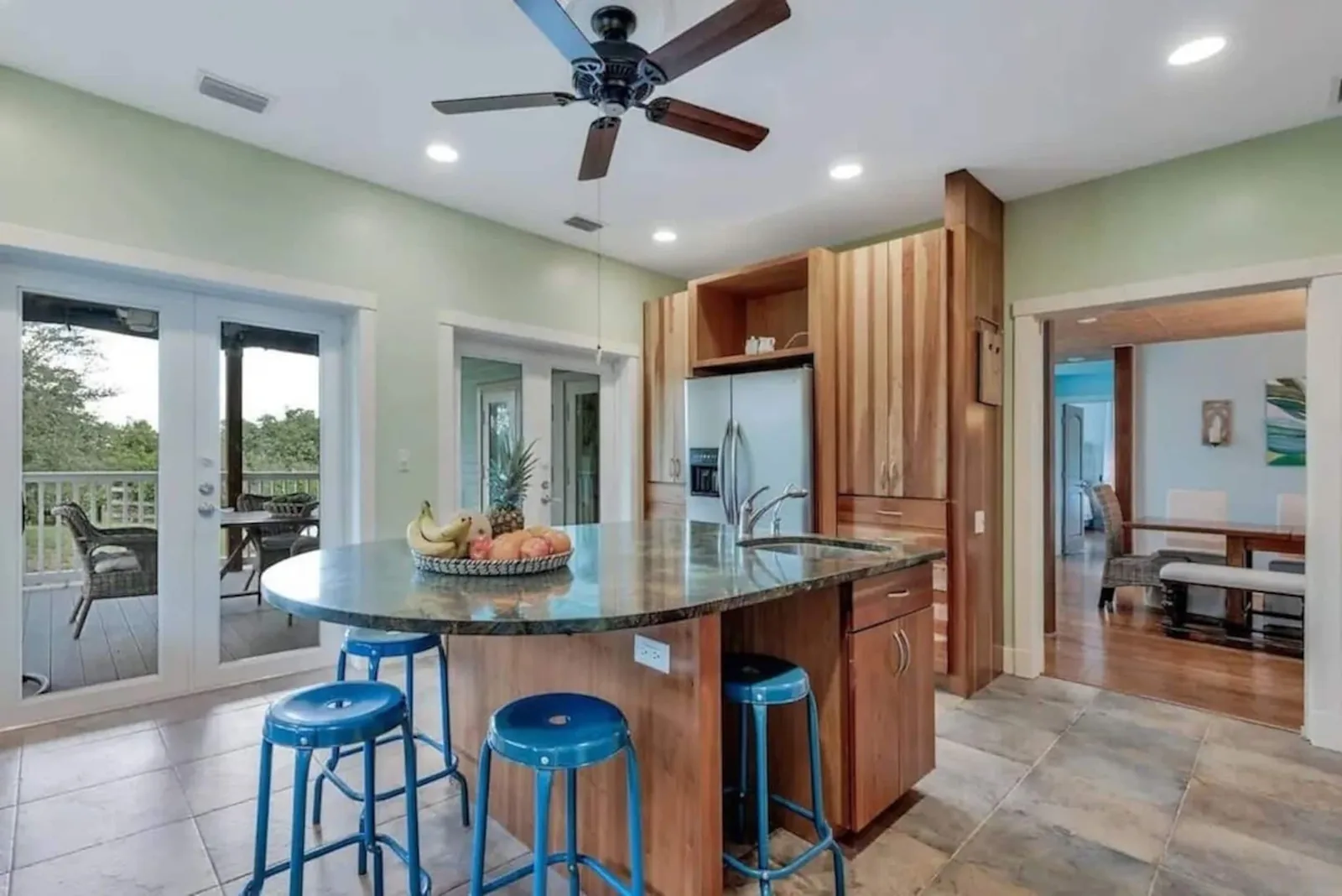 Kitchen island with blue stools and French doors