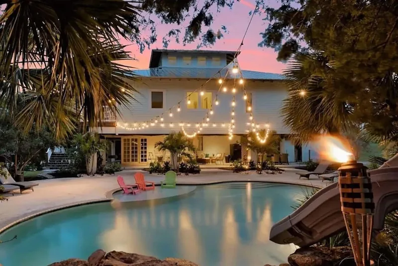 Bleu's pool and house at dusk under string lights