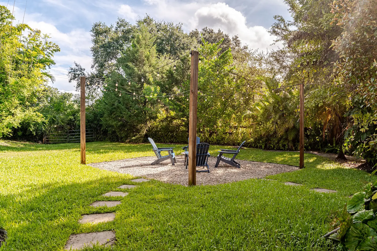 Fire pit on the lawn ringed by palms