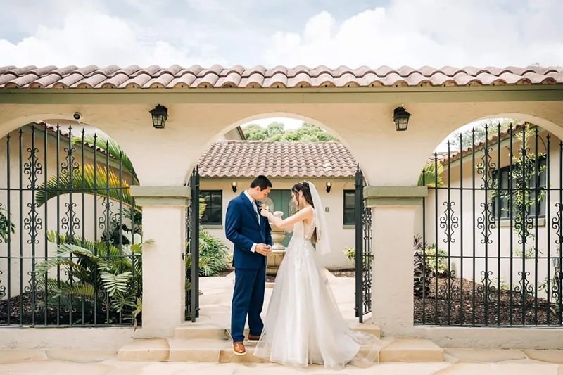 Bride and groom beneath the arches at the front gates