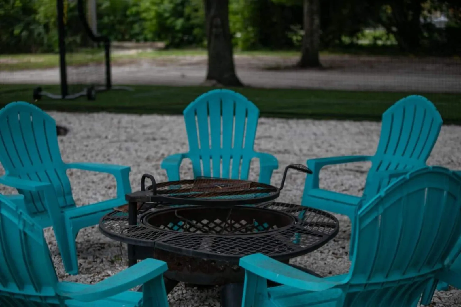 Fire pit circled by turquoise Adirondack chairs