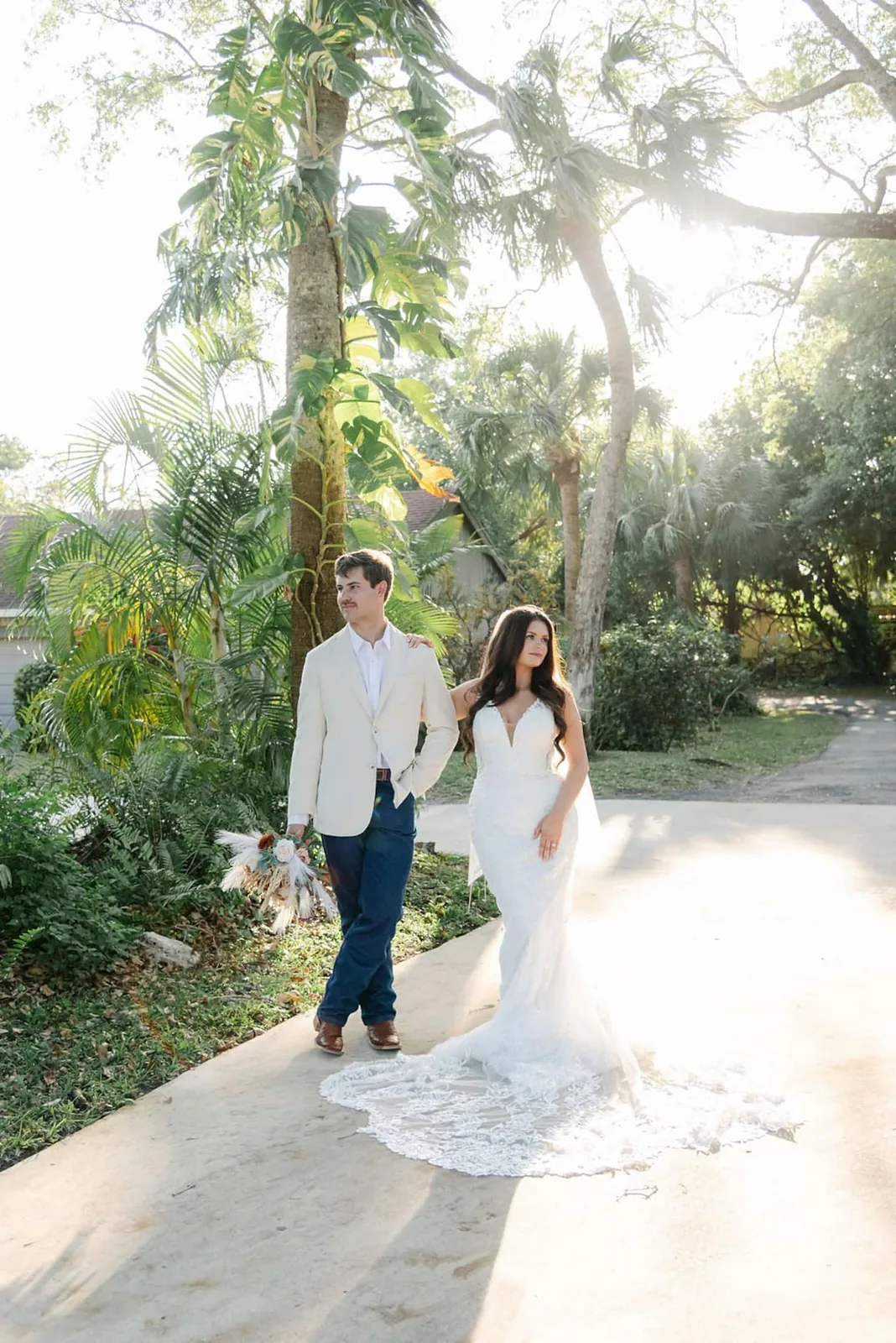 Bride and groom on the garden path under the palms