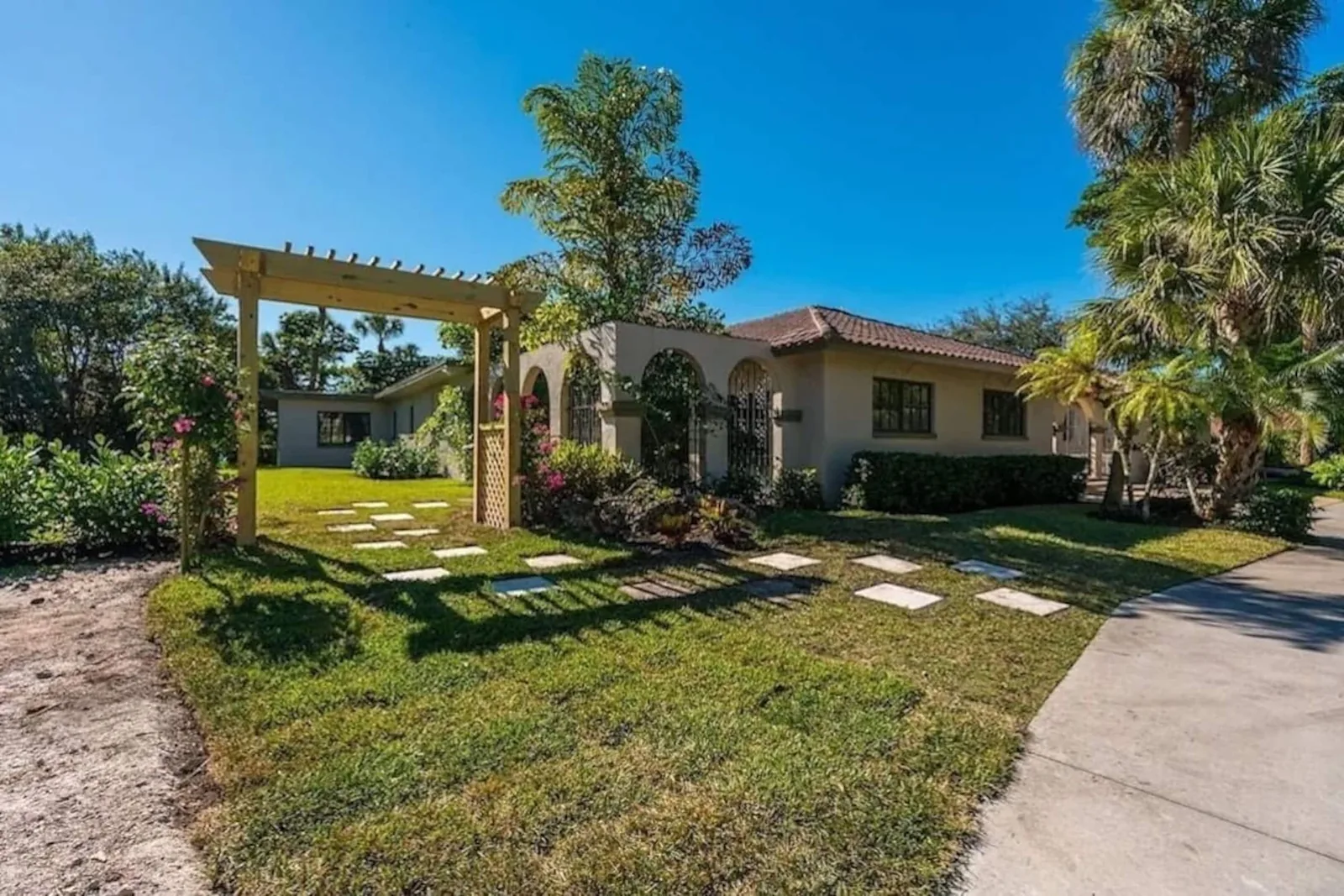 Wooden pergola and stepping-stone path beside the house