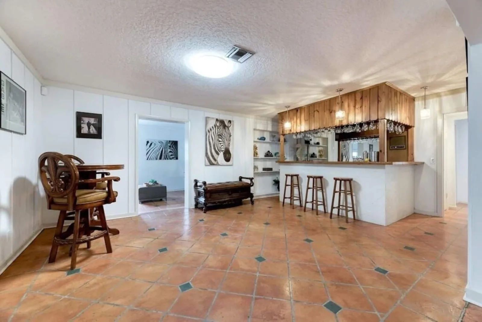 Full bar with stools and wood paneling