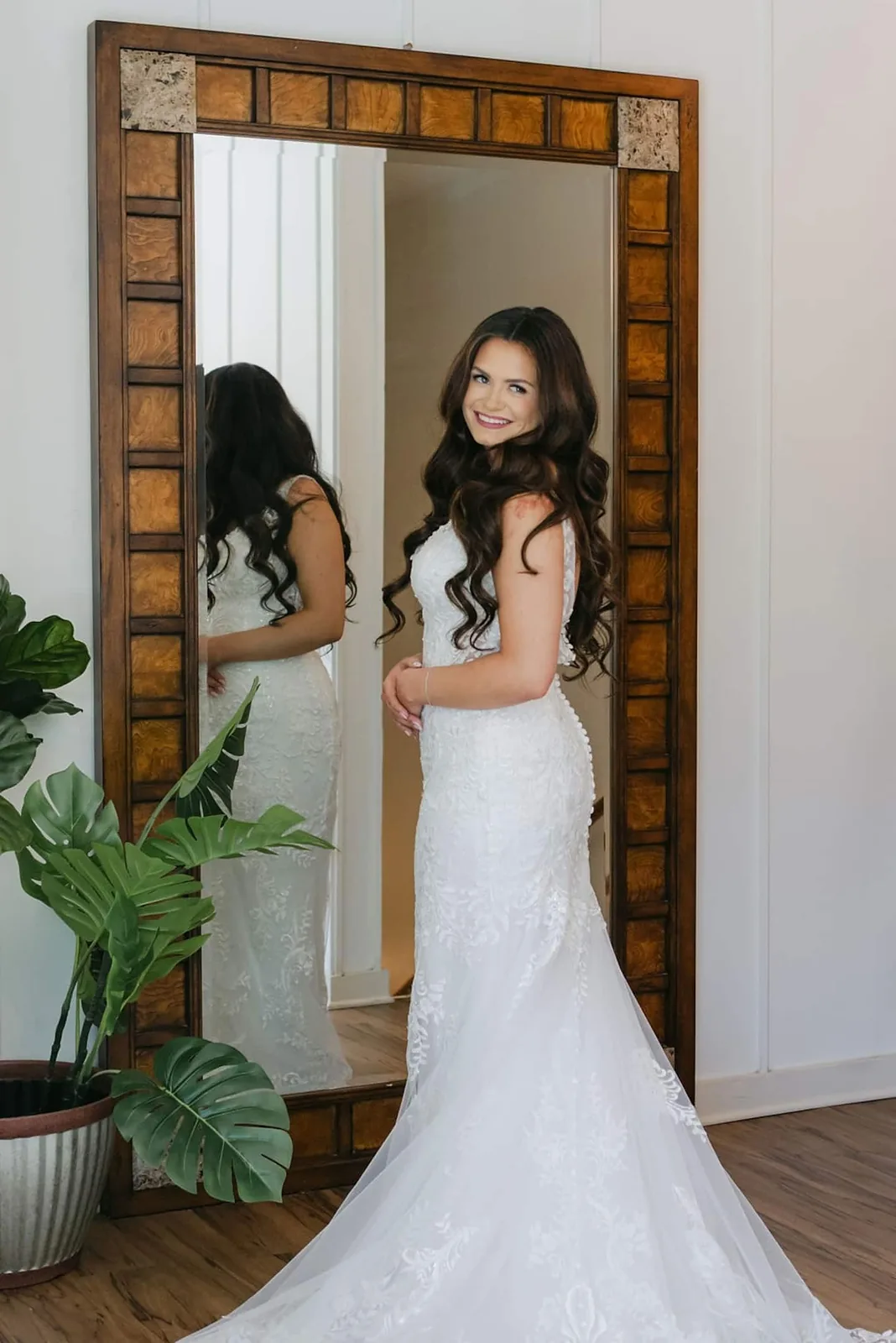 Bride at a tall mirror in the master suite