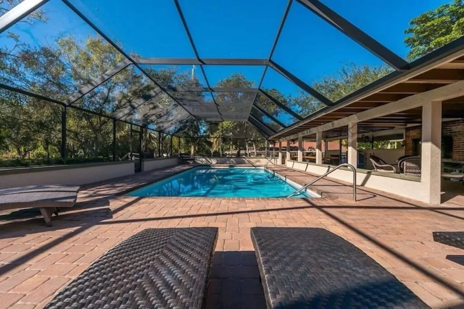 The full length of the screened pool, seen from the loungers