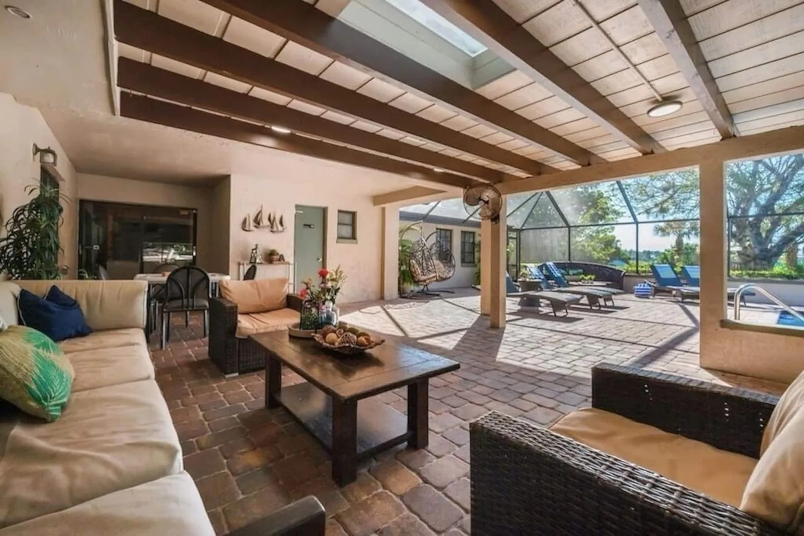 Covered lanai lounge with sofas, the pool beyond